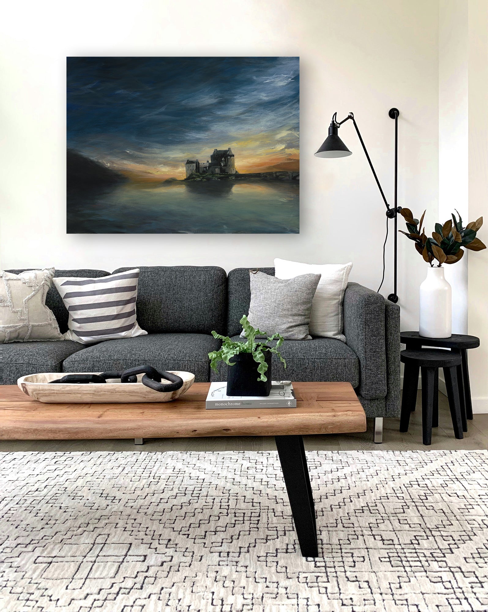 Modern living room with a gray sofa, wooden coffee table, and decorative painting on the wall.