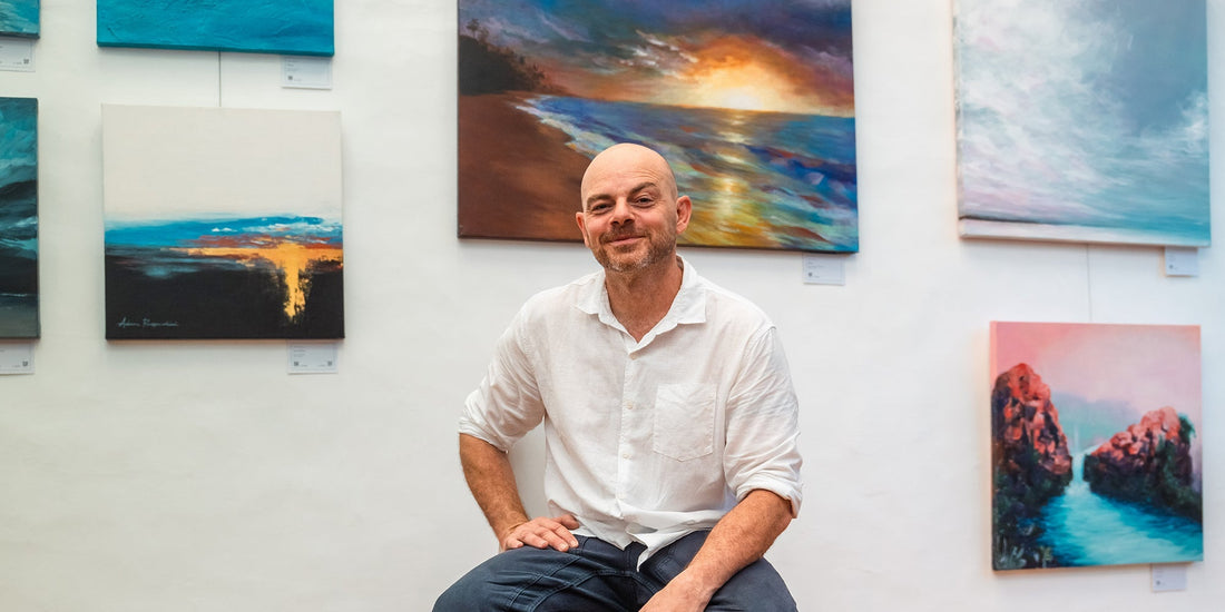 adam ruspandini artist in front of exhibition artworks