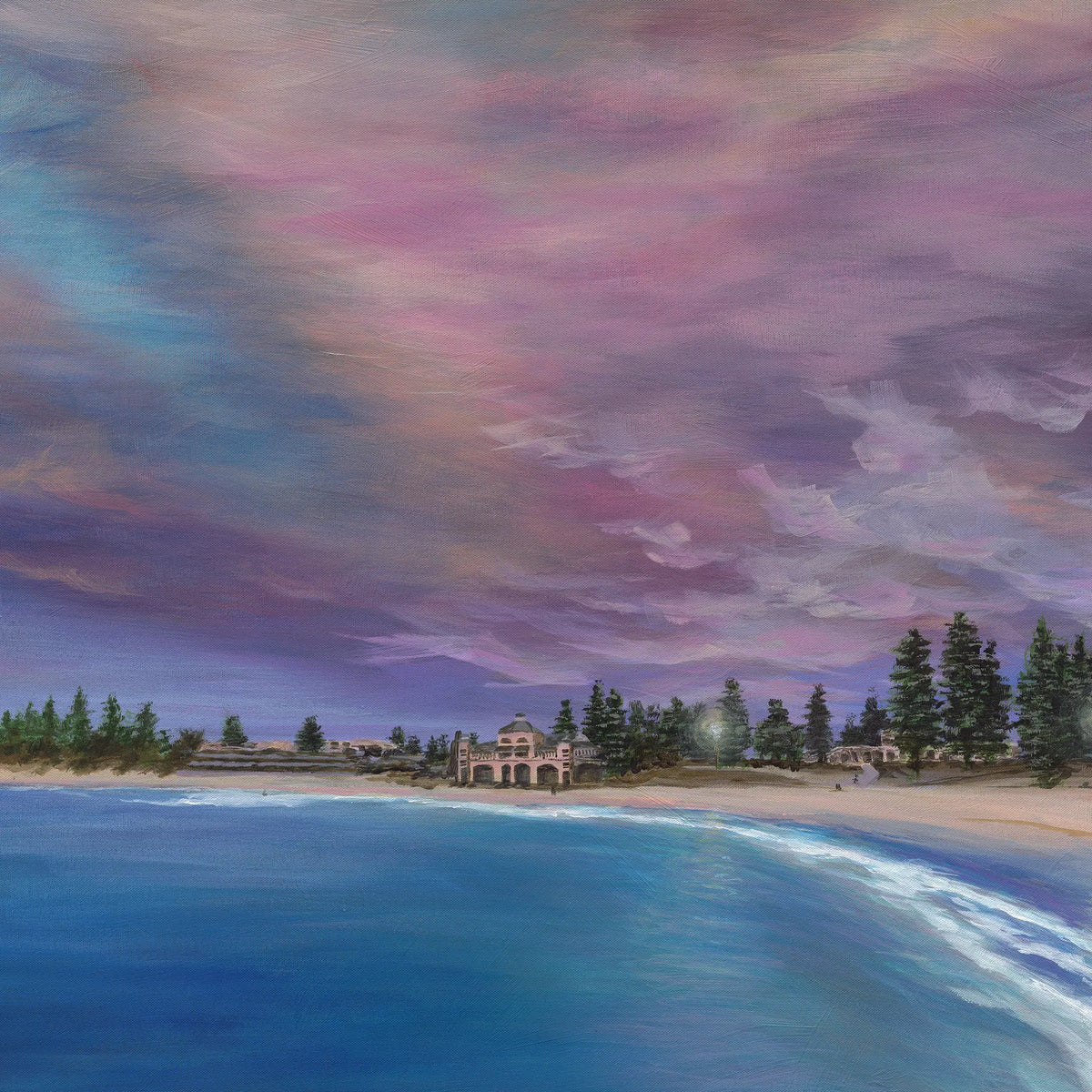 Beach scene with colorful sky and buildings in the distance
