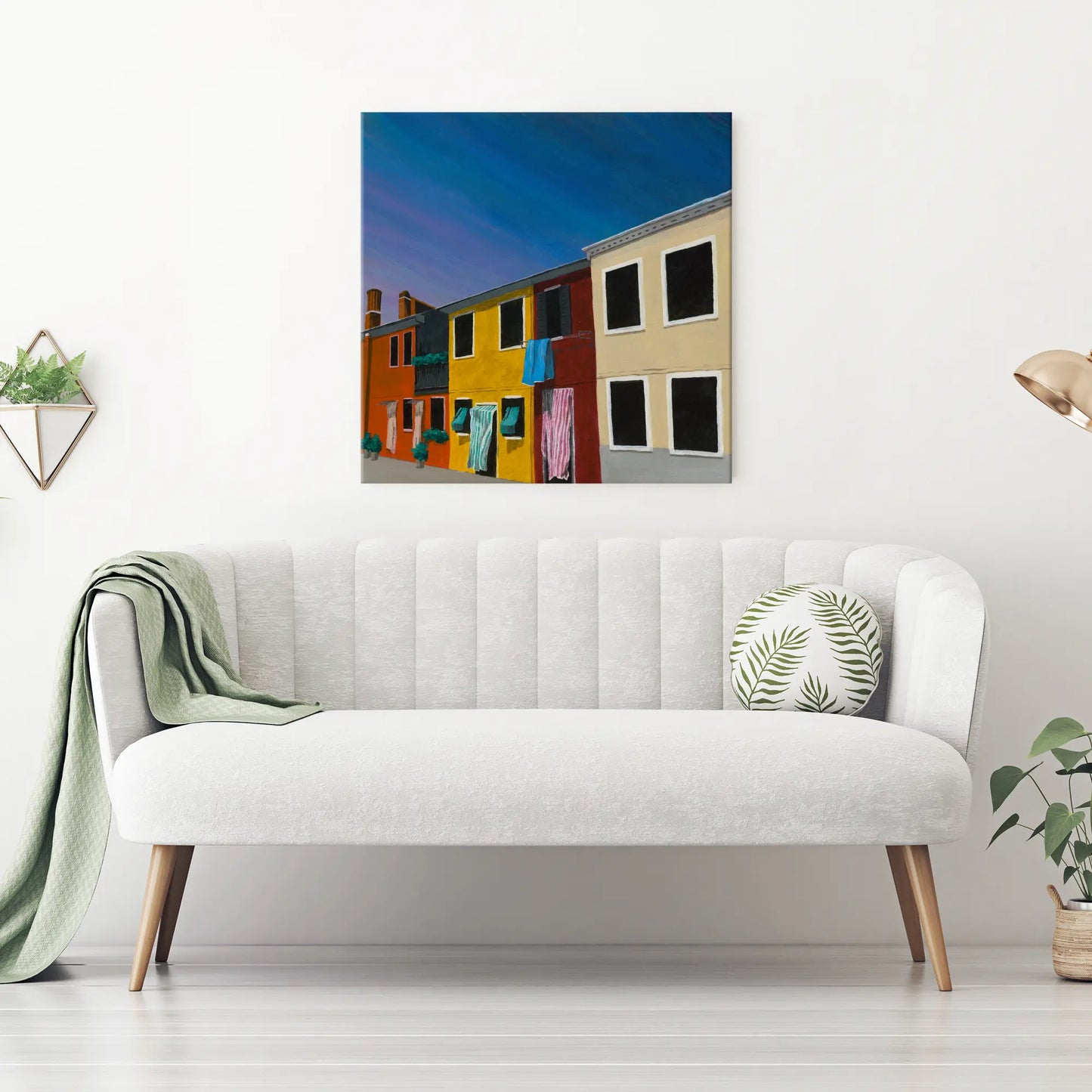 White sofa with a colorful wall art piece above it in a minimalistic living room.