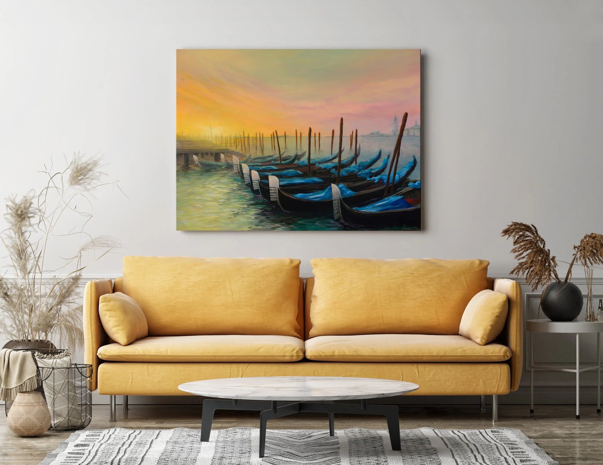 Yellow sofa in a living room with a colorful painting of gondolas on the wall.