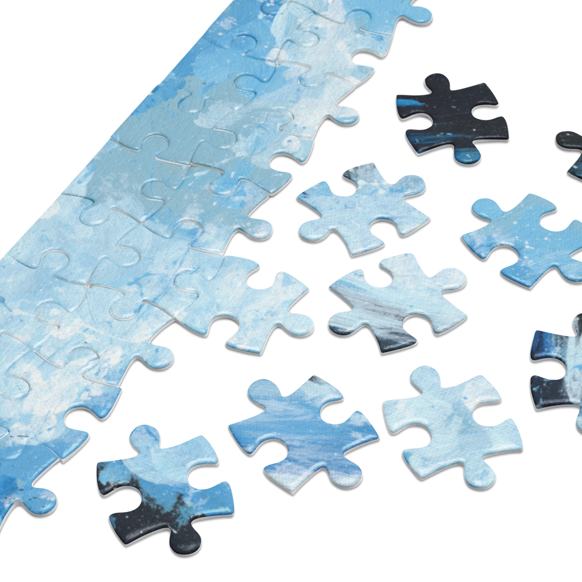 A close-up of a jigsaw puzzle showing a blue and white marbled or cloudy pattern, with several loose puzzle pieces scattered on a white background.