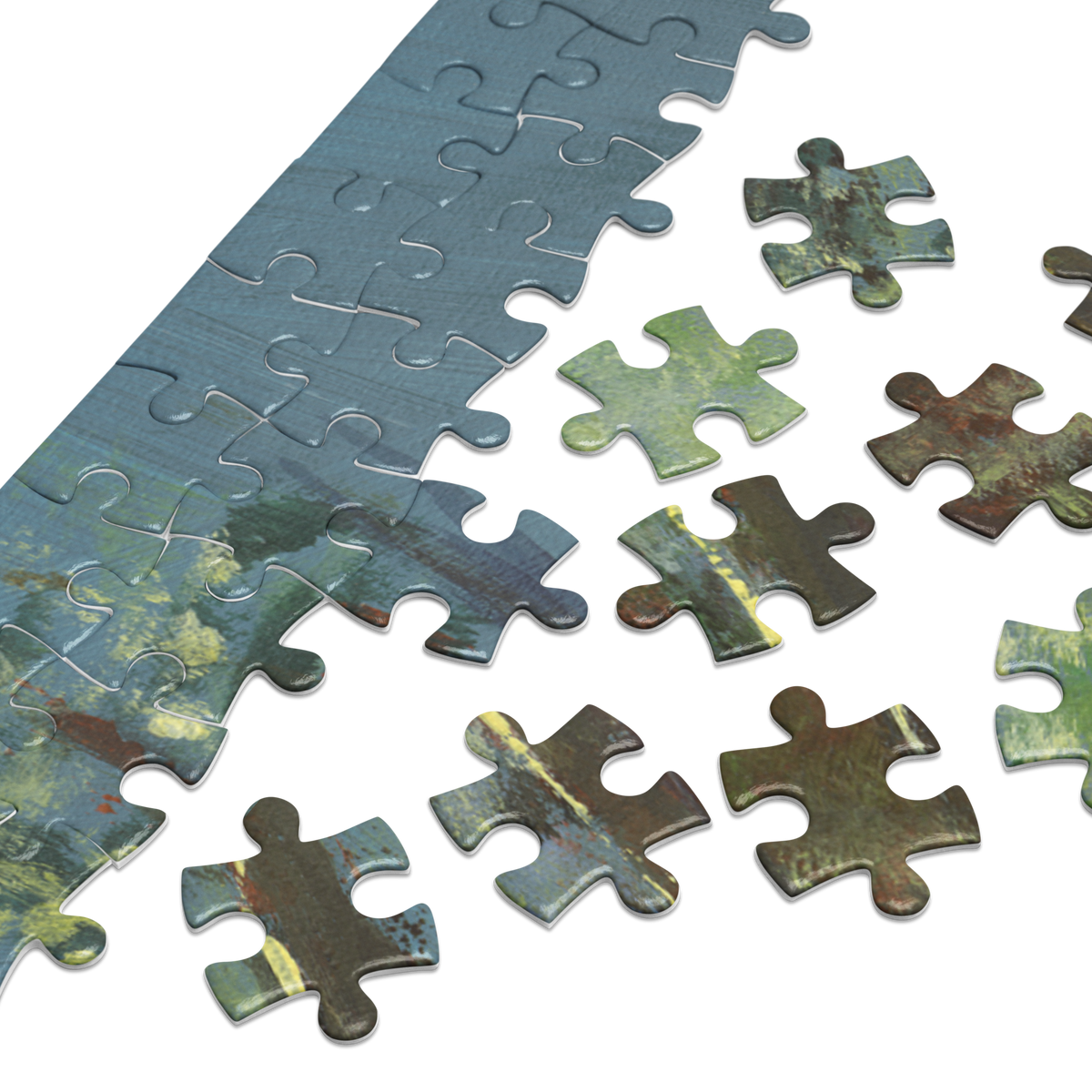 A close-up of a jigsaw puzzle showing a long strip of completed puzzle pieces with a textured blue and green landscape design, with several loose puzzle pieces scattered on a white background.