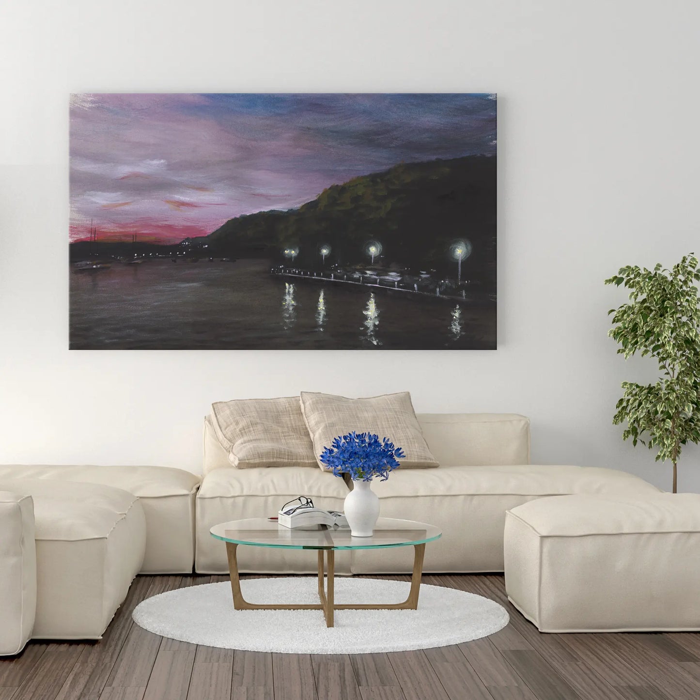 Living room with a sectional sofa, coffee table, and wall art of a lake at dusk.