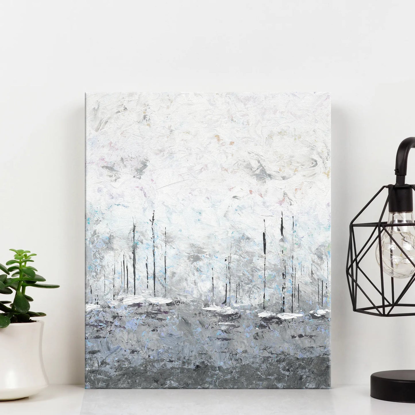 Abstract painting of yachts in misty waters on a white wall with a plant and lamp in the foreground.