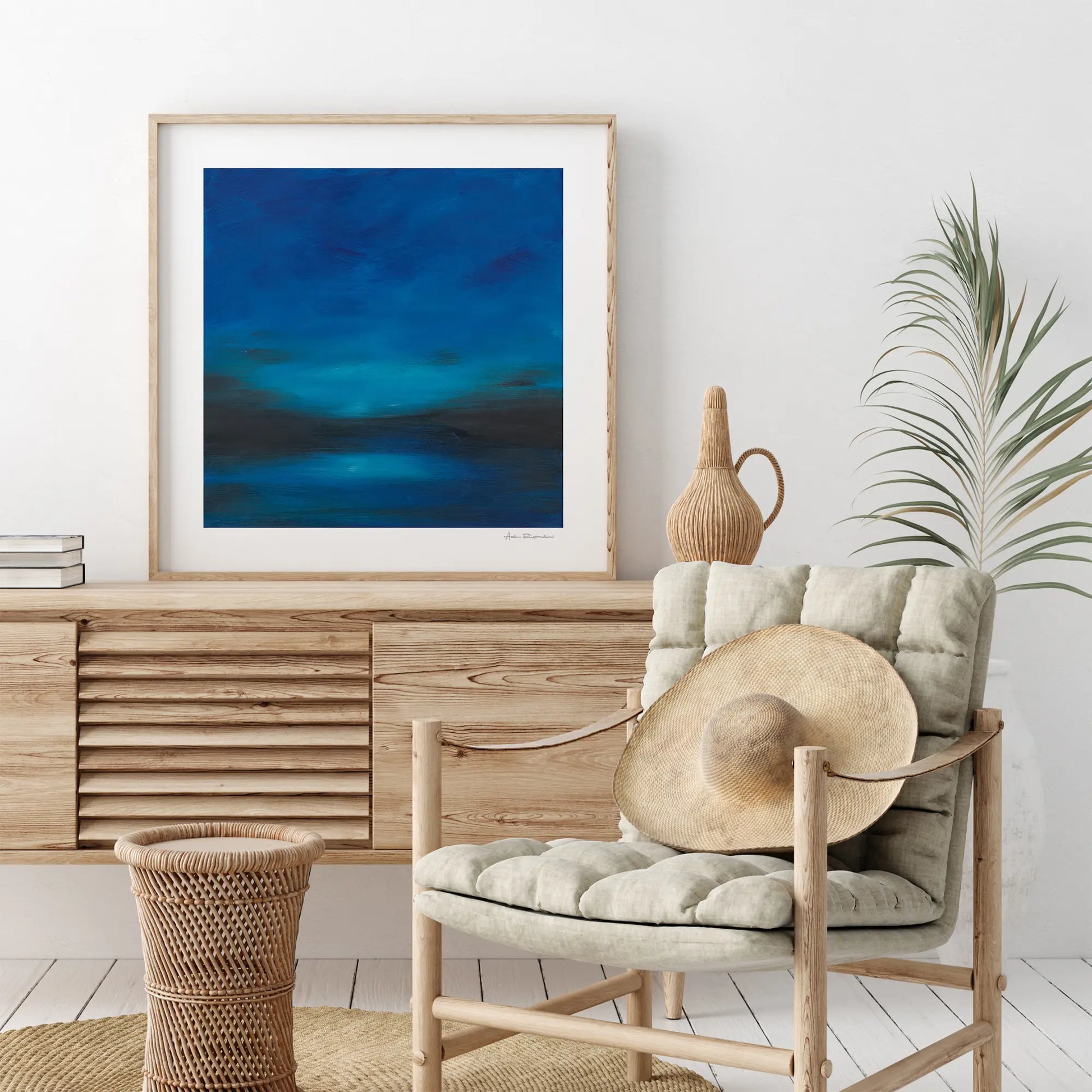Modern interior with a wooden sideboard, chair, and abstract painting on a white wall.