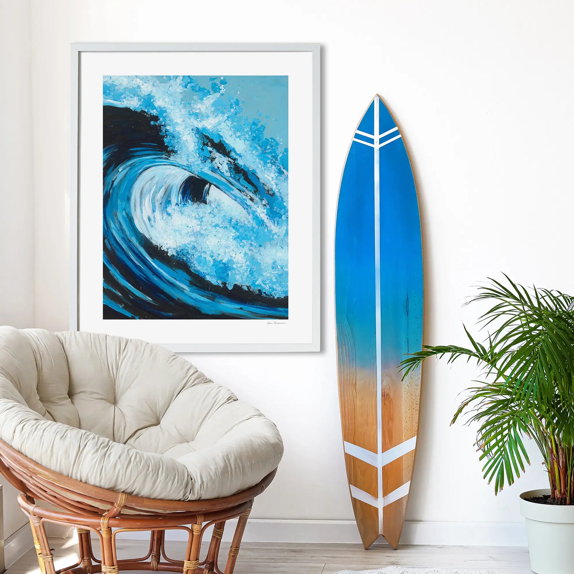 Framed artwork of a wave, surfboard with blue gradient, and chair in a room setting.